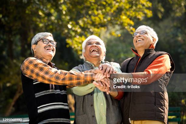 senior male friends having fun at park - senior adult stock pictures, royalty-free photos & images