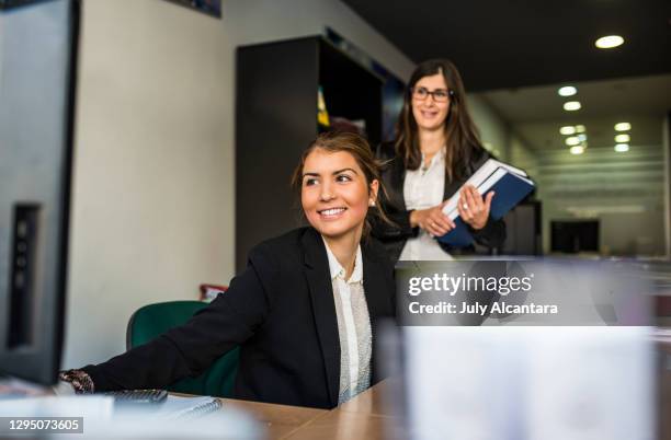 junge attraktive frauen arbeiten im büro am computer - clerk stock-fotos und bilder