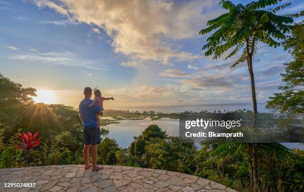 mother & daughter watching the sunrise over a lagoon and the pacific in corcovado national park on the osa peninsula in costa rica - costa rica stock pictures, royalty-free photos & images