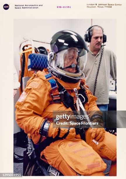 American NASA astronaut and politician John Glenn , assisted by Boeing suit technician Lloyd Armintor, during suit fitting at the flight equipment...