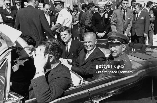 American President John F Kennedy , American NASA astronaut John Glenn and American Lieutenant General Leighton I Davis sit together in the back seat...