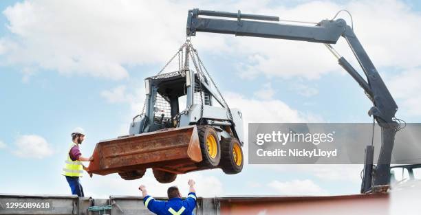 unloading of skid steer loader at construction site - hook equipment stock pictures, royalty-free photos & images