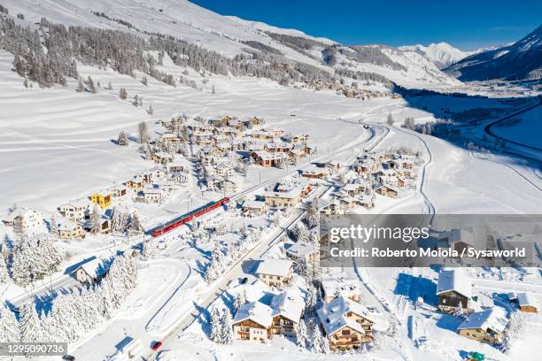 bernina express train in the alpine village covered with snow, switzerland - st moritz stock-fotos und bilder