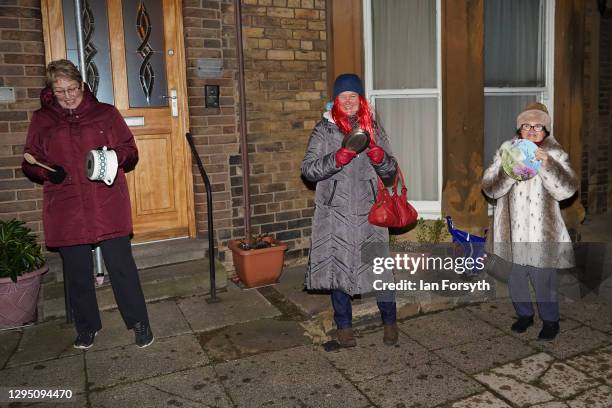 Residents of a street in Saltburn stand socially distanced outside their homes and take part in the Clap for Heroes event on January 07, 2021 in...
