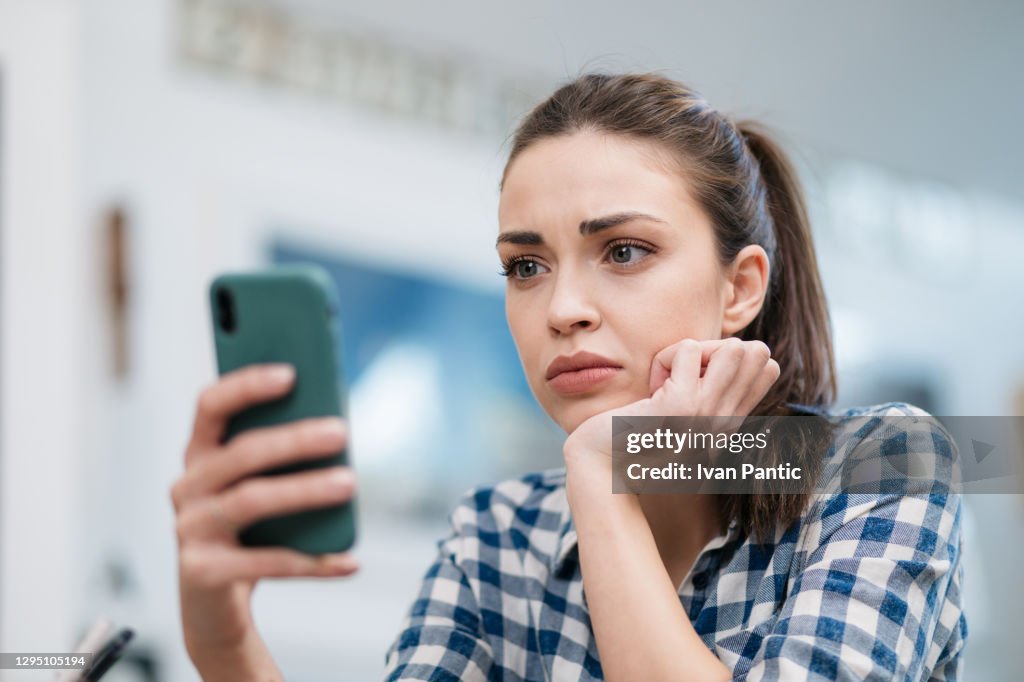 Close-up de uma triste jovem caucasiana lendo más notícias