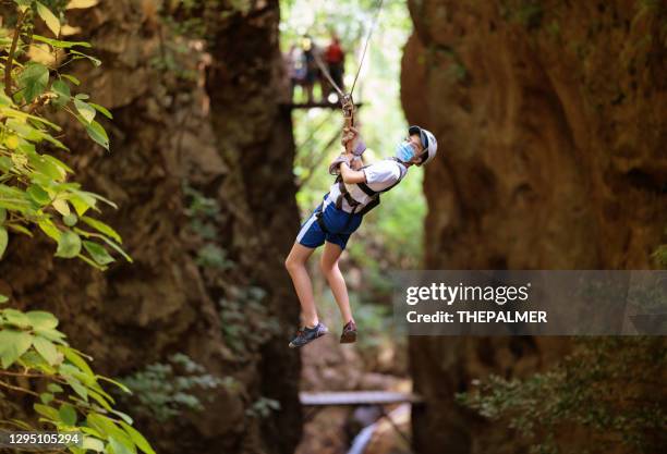 teenager on a zip line in costa rica wearing protective mask - costa rica zipline stock pictures, royalty-free photos & images