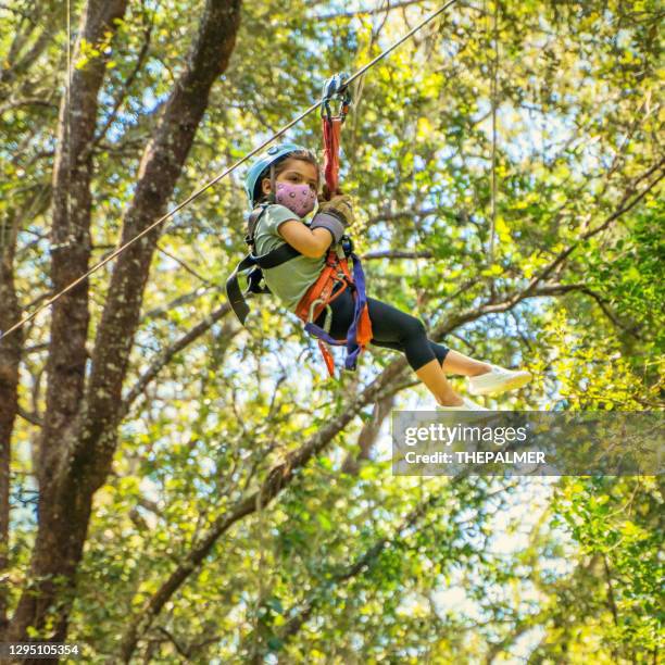 little girl wearing protective mask on a zip line in costa rica - costa rica zipline stock pictures, royalty-free photos & images