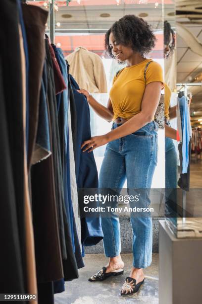 young woman shopping in clothing store - denim store stock pictures, royalty-free photos & images