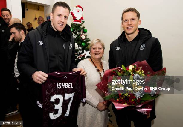 Hearts Captain Christophe Berra and Colin Doyle hands over gifts to retiring NHS worker Ishbel Proctor.