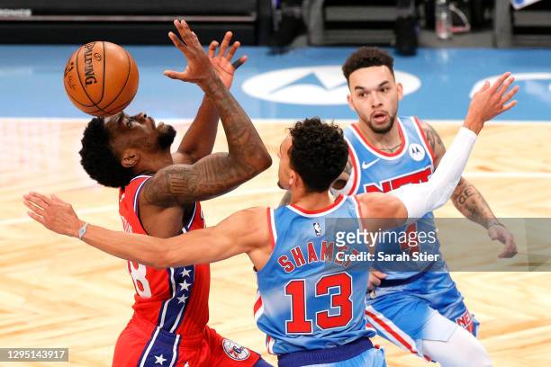 Shake Milton of the Philadelphia 76ers loses control of the ball as Landry Shamet and Chris Chiozza of the Brooklyn Nets defend during the first half...