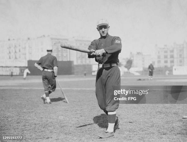 American baseball player Ty Cobb , Detroit Tigers outfielder, poses as if he is swinging a baseball bat, possibly on the training field, location...