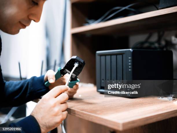 man preparing cables for for network attached storage system, concept for nas usage at home or at small businesses - installing software stock pictures, royalty-free photos & images