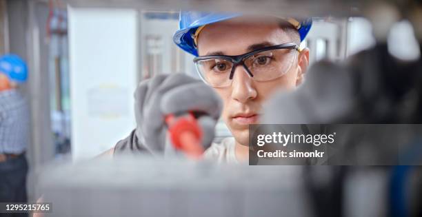 electrician working at construction site - electrician stock pictures, royalty-free photos & images