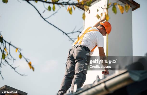 roofer misura camino sul tetto - canna fumaria foto e immagini stock