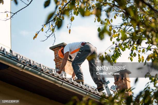 roofer measuring chimney on roof top - up on a roof stock pictures, royalty-free photos & images