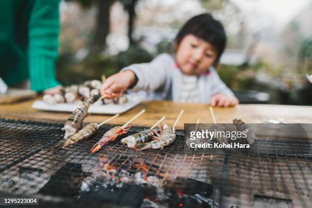 asian girl grilling shrimps outdoors - bbq shrimp stock pictures, royalty-free photos & images