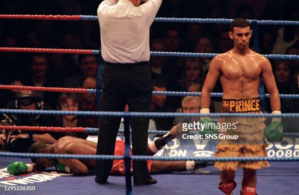 Prince Naseem Hamed prepares to celebrate his victory as Said Lawal lies prostrate in the ring.