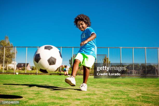 bellissimo giovane ragazzo nero che si allena sul campo da calcio - sports activity foto e immagini stock