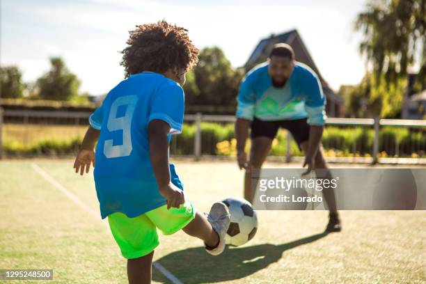 formation noire de père et de jeune fils sur le terrain de football - father son challenge round two photos et images de collection