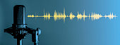 Studio microphone on blue background with yellow waveform, Podcast or recording studio banner