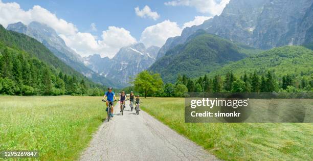 family riding bicycles on country road - cross country road trip stock pictures, royalty-free photos & images