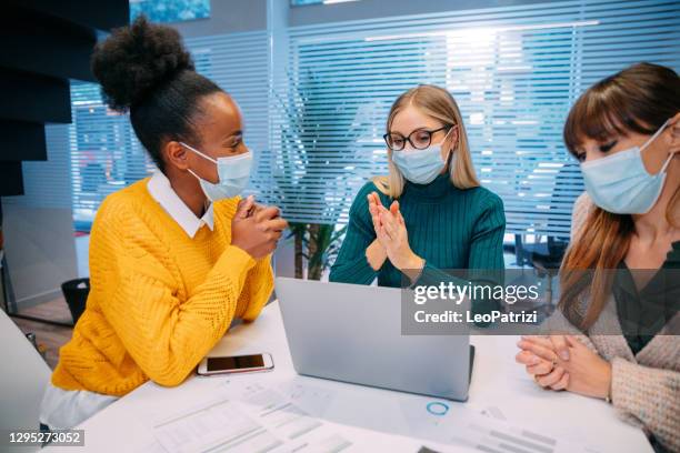 woman at work in the office wearing protective face covering mask - business meeting with masks stock pictures, royalty-free photos & images