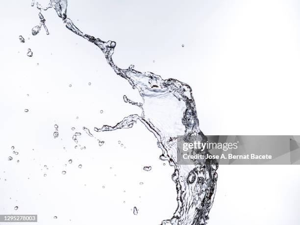 full frame of the textures formed  by the water jets to pressure with drops floating in the air on a white background - water splash white background stockfoto's en -beelden