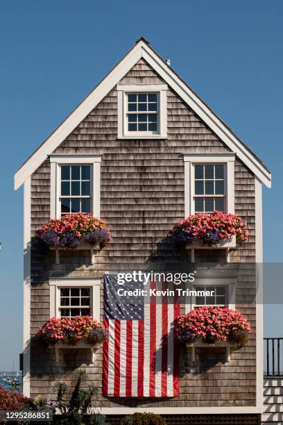 american flag hung on side of beach house - nouvelle angleterre états unis photos et images de collection