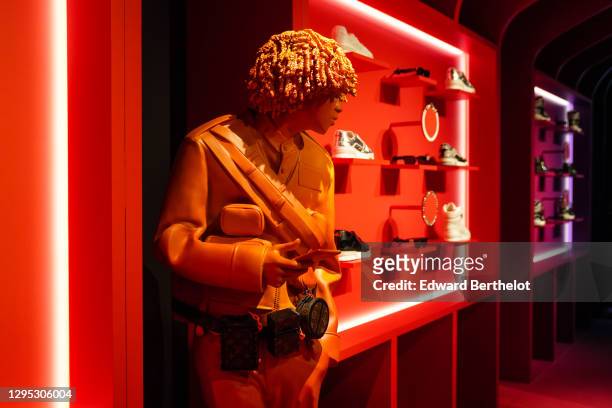 General view of a displayed mannequin wearing a brown leather Vuitton monogram print belt bag, next to displayed LV Trainer sneakers, during the...