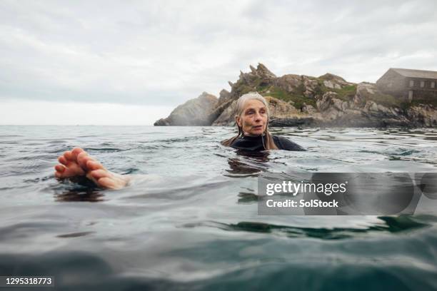 relaxing in the water - older woman wet hair stock pictures, royalty-free photos & images