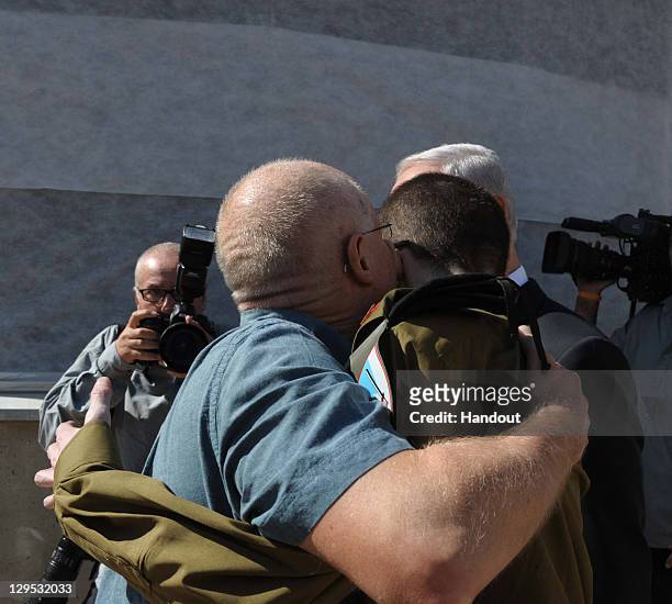 In this handout photo provided by the Israeli Defence Force, freed Israeli soldier Gilad Shalit hugs his father Noam Shalit in front of Israeli Prime...