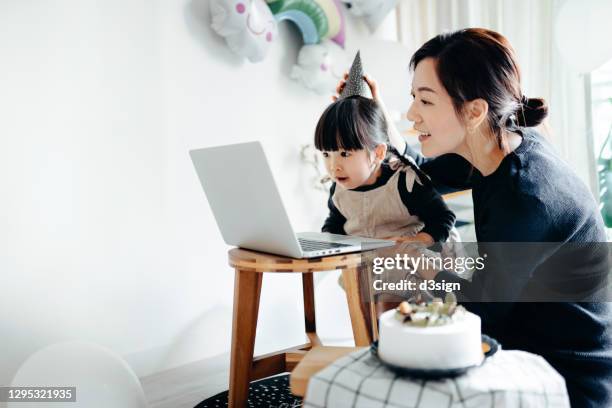 lovely asian girl and mother celebrating birthday with friends / family by having a virtual birthday party at home. enjoying birthday celebration in front of the laptop during pandemic. practicing social distancing. birthday lifestyle theme - zoom birthday stock pictures, royalty-free photos & images