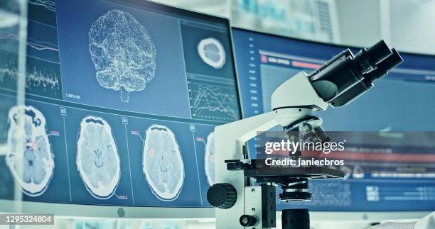 matériel de laboratoire, microscope et ordinateurs. recherche sur les ondes cérébrales sur les écrans. vue latérale du scientifique - microscope side view photos et images de collection
