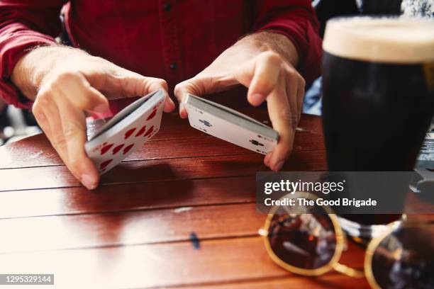 man shuffling a deck of cards in a pub in ireland - irish pub stock-fotos und bilder