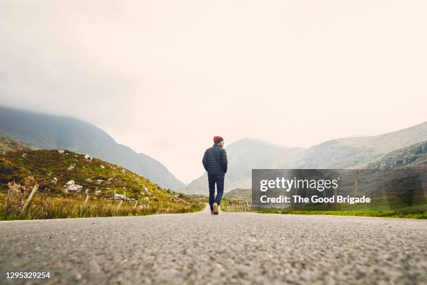 man walking down a country road in killarney, ireland - looking down stock-fotos und bilder