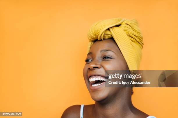 smiling woman with yellow turban - scarf isolated stock pictures, royalty-free photos & images