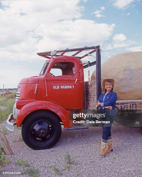 Actress Dawn Wells poses for a portrait in Driggs Idaho in front of a red spud potato truck in 2000.