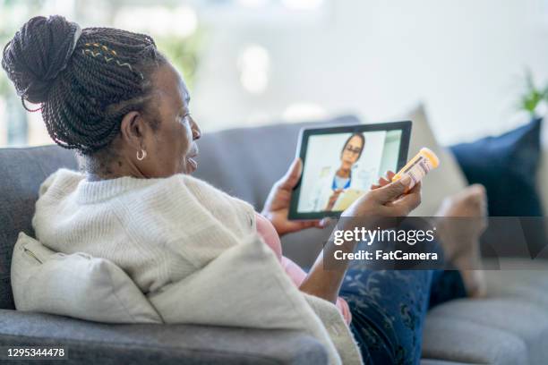 telemedicine call between a senior woman and her doctor - telemedicine visit stock pictures, royalty-free photos & images