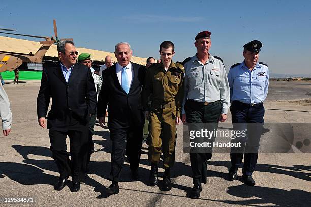 In this handout photo provided by the Israeli Defence Force, freed Israeli soldier Gilad Shalit walks with Israeli Prime Minister Benjamin Netanyahu...