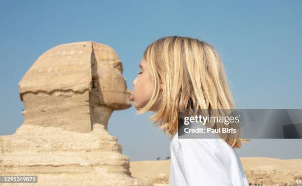cute little boy kissing the sphinx in cairo, egypt - limestone pyramids stock pictures, royalty-free photos & images