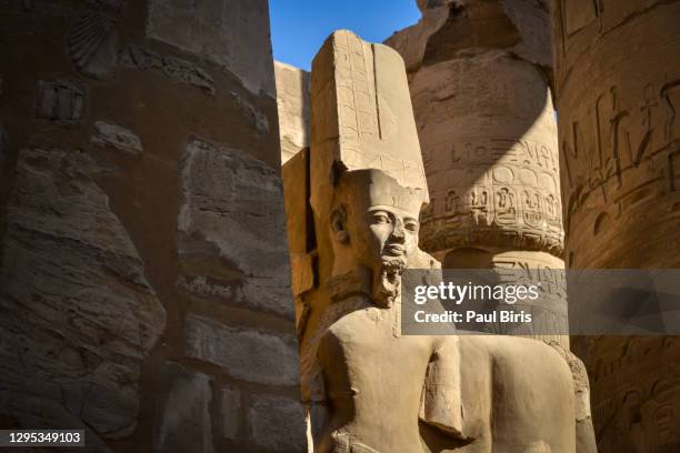 statue of the deity amun ra in the great hypostyle hall, karnak temple complex, luxor, egypt - tempel von karnak stock-fotos und bilder