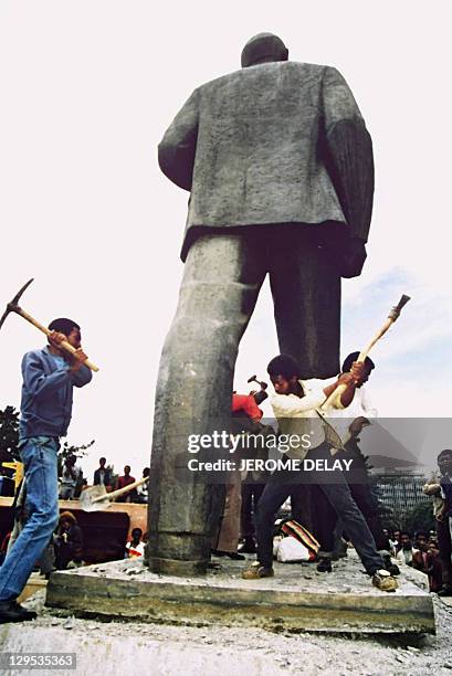 Man takes a shot at toppling the statue of Russian Bolshevik revolutionary leader Vladimir Ilyich Lenin as workers begin dismantling 23 May 1991 in...