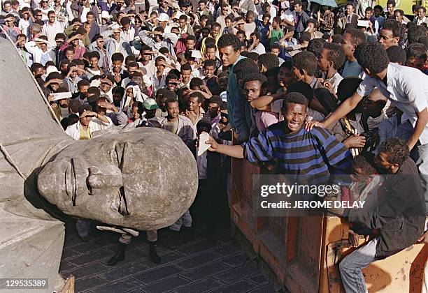 Cheering crowd of Ethiopian youths surrounds the toppled statue, sculptured in a pure style of socialist realism, of Russian Bolshevik revolutionary...