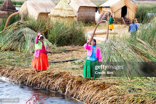 indigene menschen auf schwimmender uros-insel im titicacasee bei puno - uros inseln stock-fotos und bilder