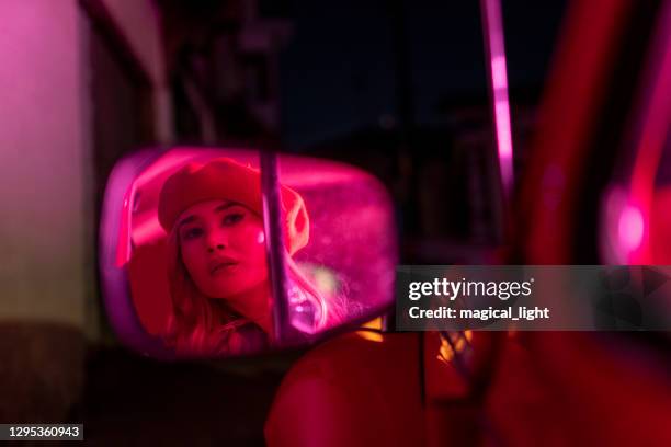 young woman night looking in the car mirror - mirrors while driving stock pictures, royalty-free photos & images