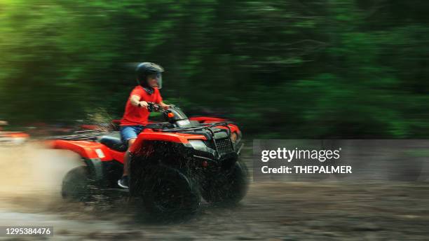 オフロード車のパンニングモーションを運転する十代の少年 - quadbike ストックフォトと画像