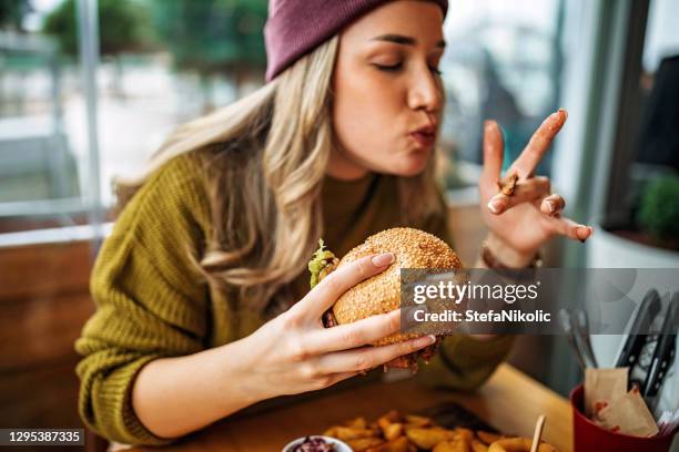 tastes like heaven - woman eating fast food stock pictures, royalty-free photos & images