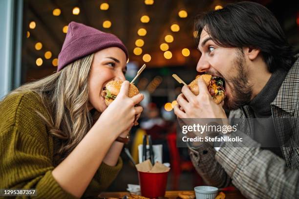 het is lief als jij. - woman eating burger stockfoto's en -beelden