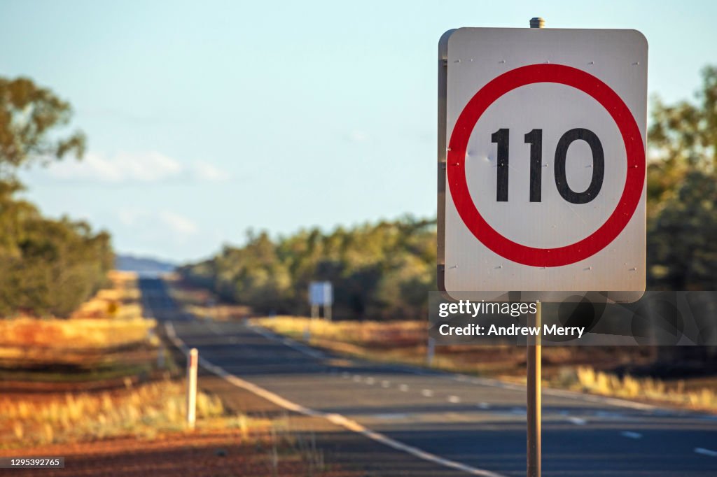 Speed limit road sign 110 kilometres per hour, empty highway in outback Australia