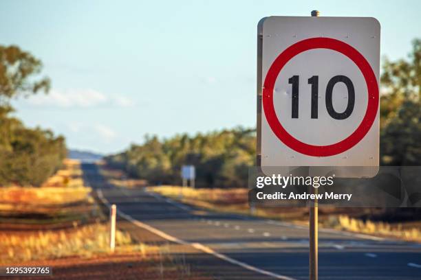 speed limit road sign 110 kilometres per hour, empty highway in outback australia - kilometer imagens e fotografias de stock